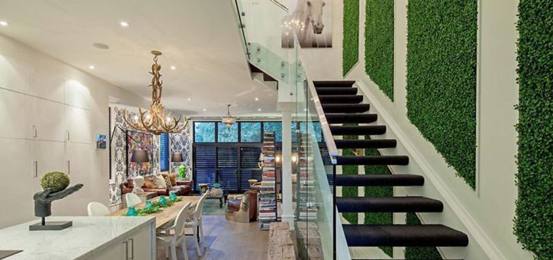 Modern staircase with green wall and glass railing